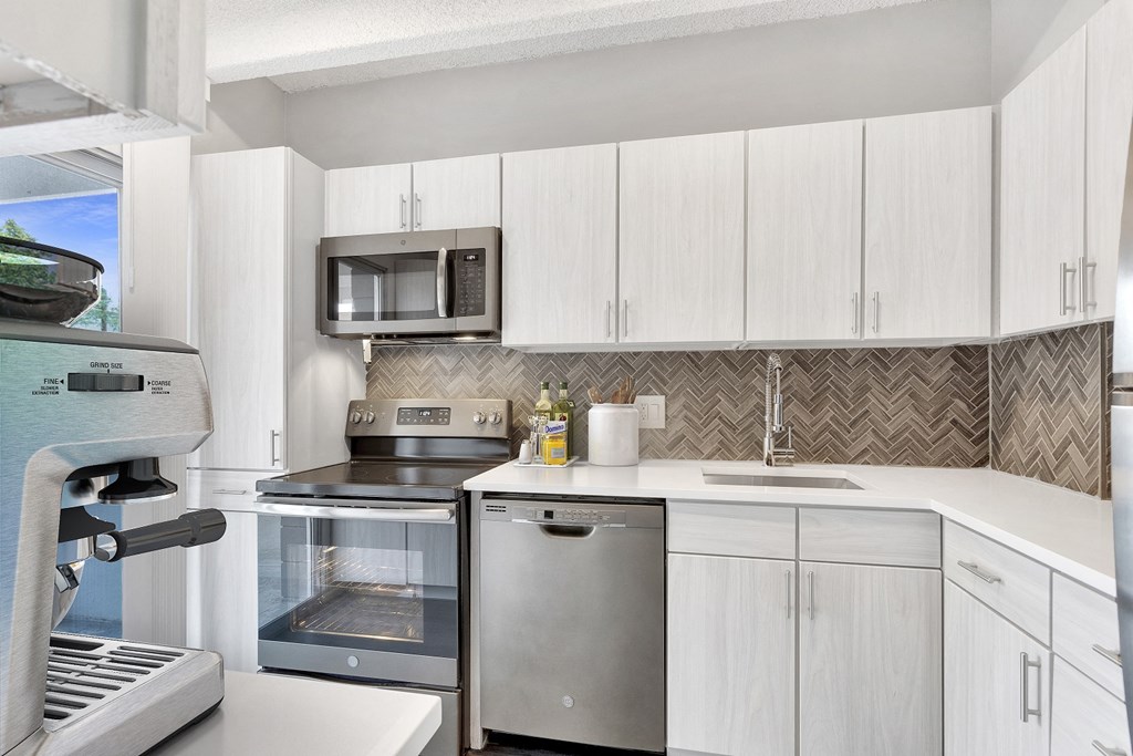 a kitchen with white cabinets and stainless steel appliances