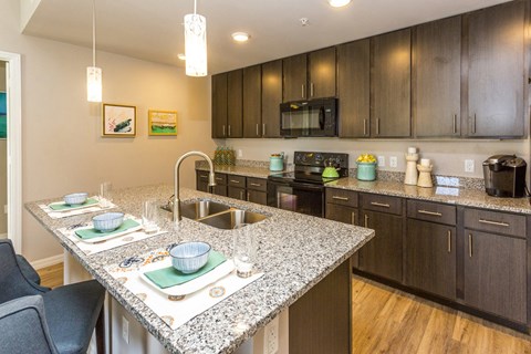 a kitchen with granite counter tops and wooden cabinets