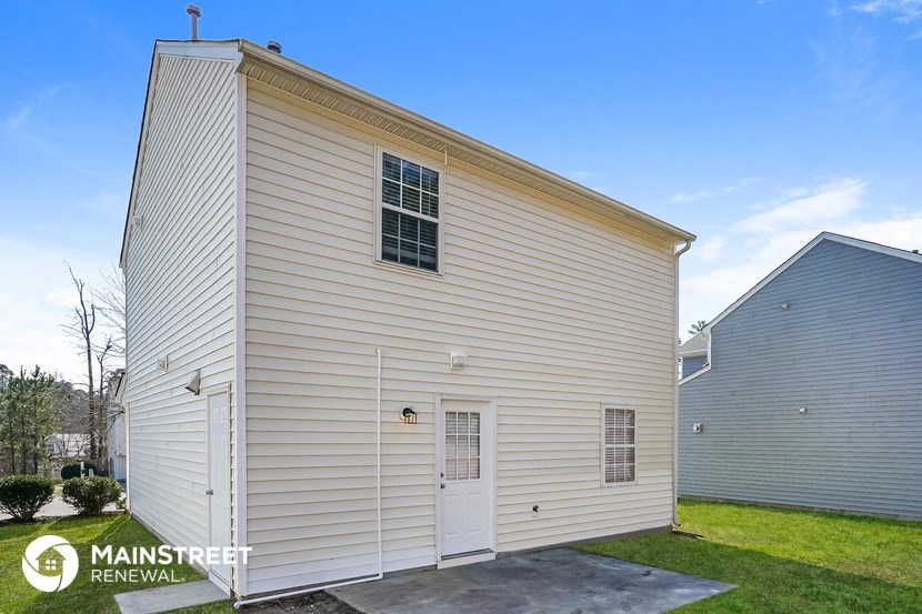 the outside of a small white church with a garage door and grass