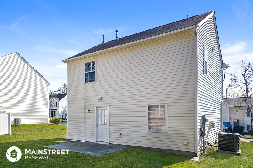 the front of a white house with a garage and a lawn