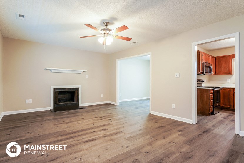 a living room with a fireplace and a ceiling fan