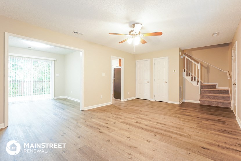 a living room with hardwood floors and a ceiling fan