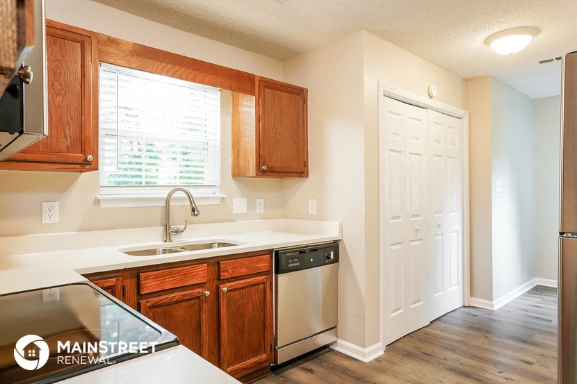 a kitchen with wooden cabinets and a sink and a refrigerator