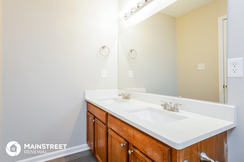 a bathroom with a white sink and a large mirror