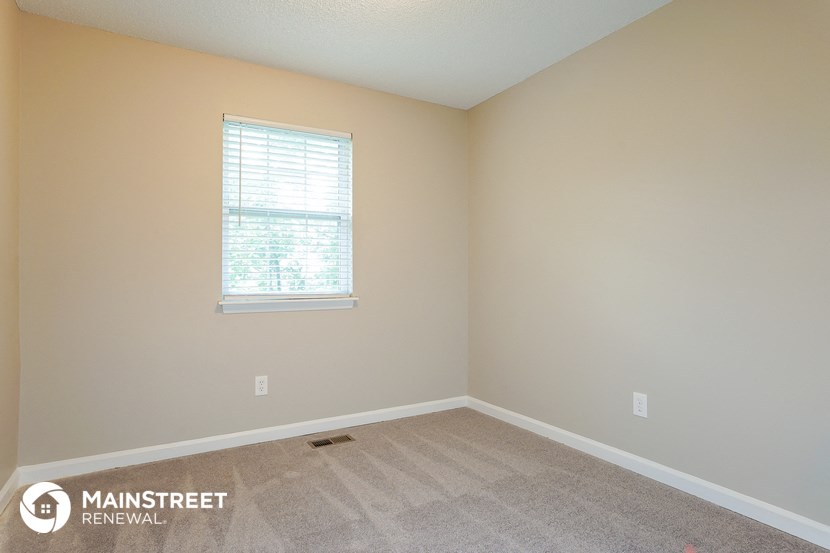 an empty room with carpet and a window