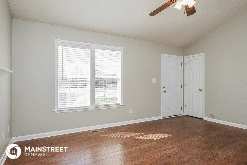 the master bedroom has a hardwood floor and a ceiling fan