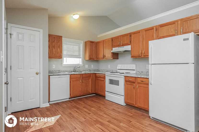 a kitchen with wood flooring and white appliances