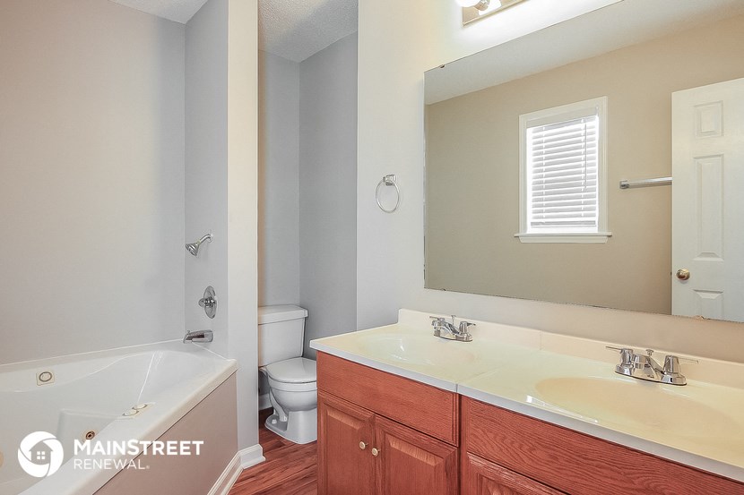 a bathroom with a tub and a sink and a mirror