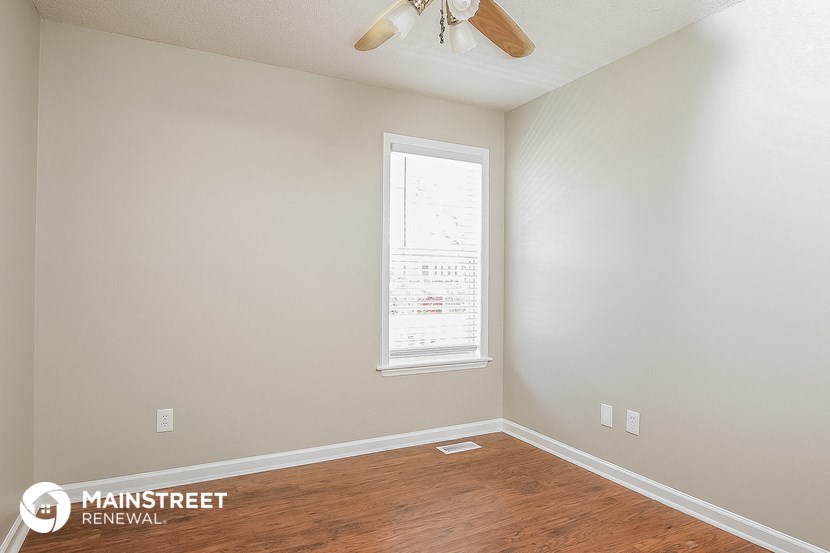 a bedroom with a ceiling fan and a window