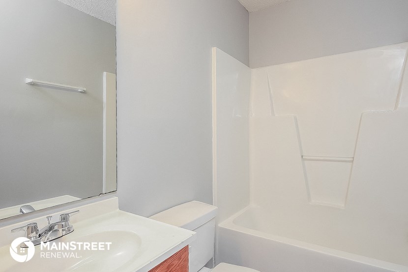 a bathroom with a toilet and a sink and a bath tub