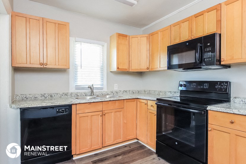 a kitchen with wood cabinets and black appliances and a sink