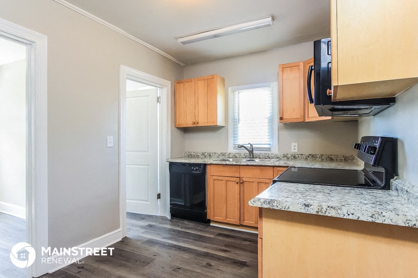 a kitchen with wooden cabinets and granite counter tops and a black appliances