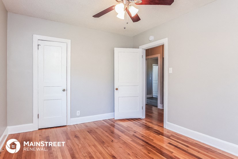 a living room with wood floors and a ceiling fan
