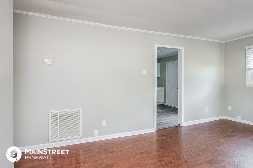 the living room of an empty house with wood floors