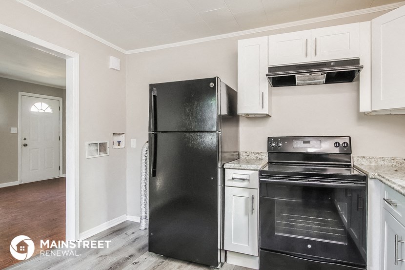a kitchen with black appliances and white cabinets