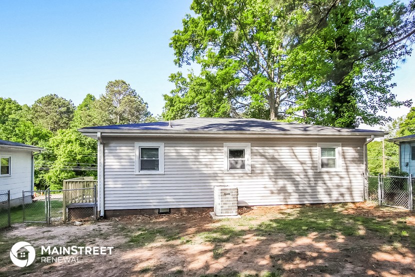 a small white house with a yard and trees