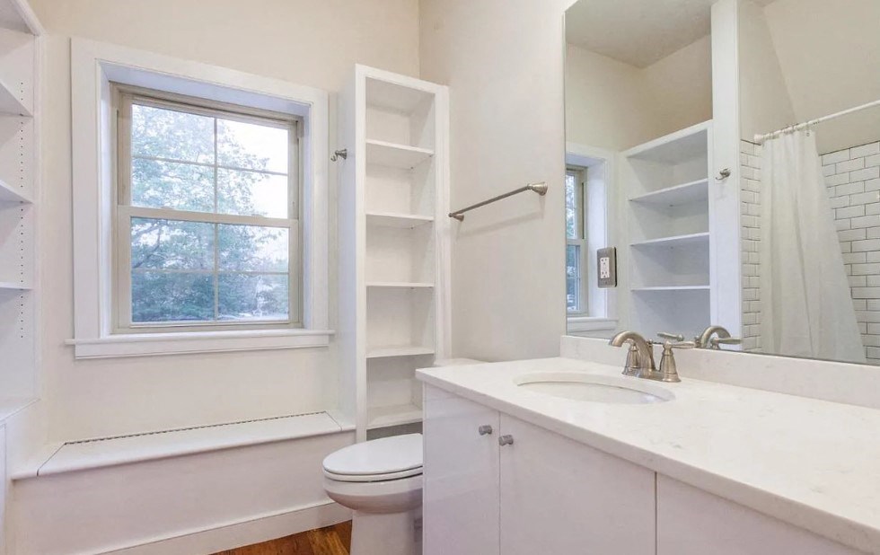 a bathroom with a sink toilet and a window
