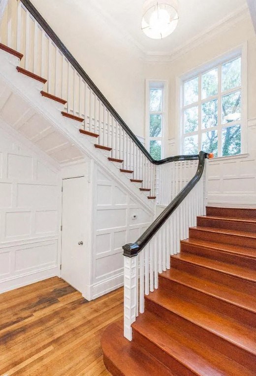 a staircase in a house with wood floors and a window