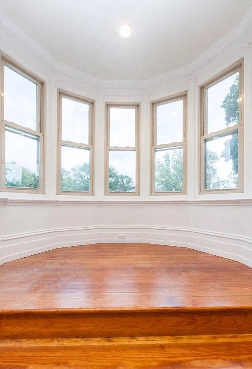 an empty room with a wood floor and a row of windows