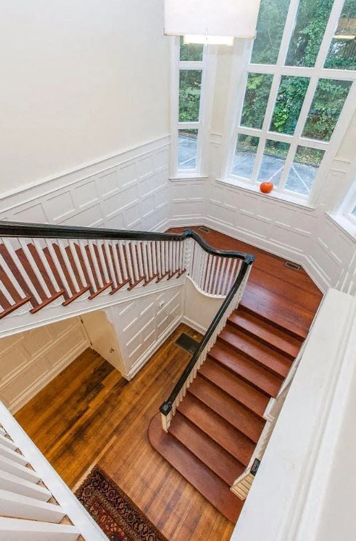 a view of a staircase with wood floors and a window