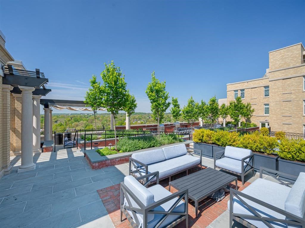 a patio with couches and tables on a rooftop