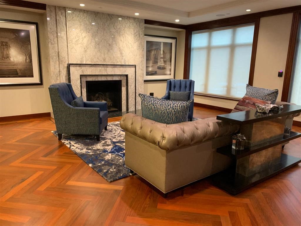 a living room with a couch and chairs in front of a fireplace