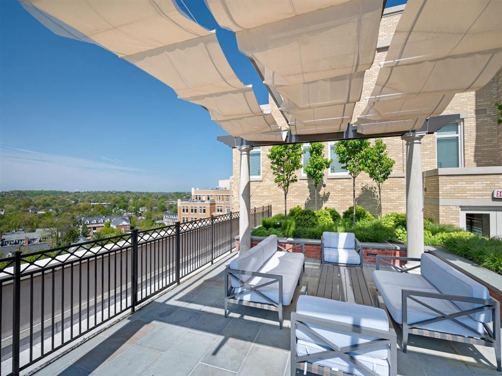 a balcony with a table and chairs and a white canopy
