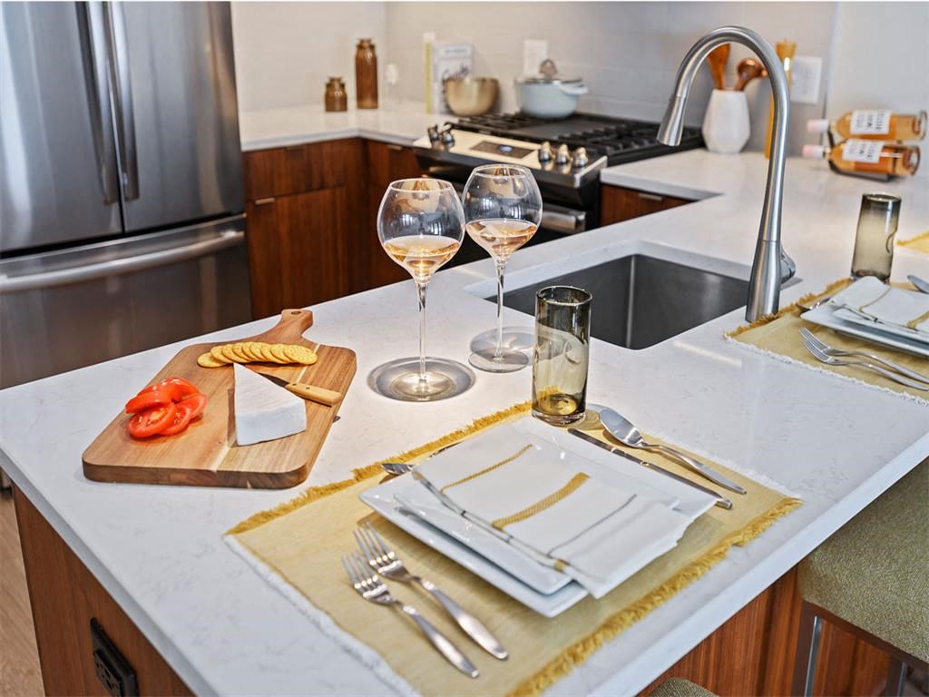 a kitchen counter with glasses of wine and a napkin on it