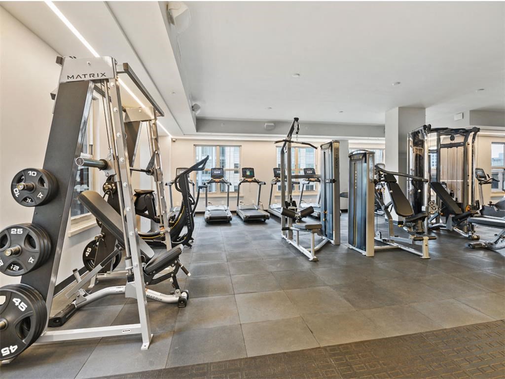 a gym with weights and cardio equipment in a building