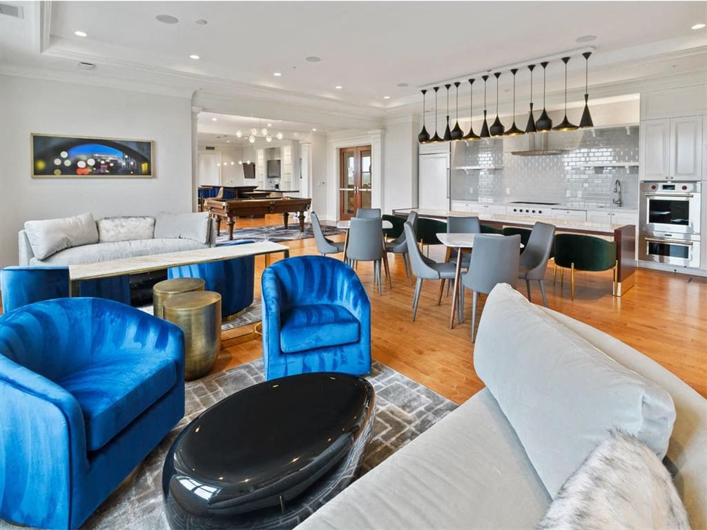 a large living room with a kitchen and blue chairs