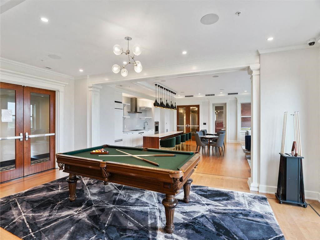 a living room with a pool table in the middle of it
