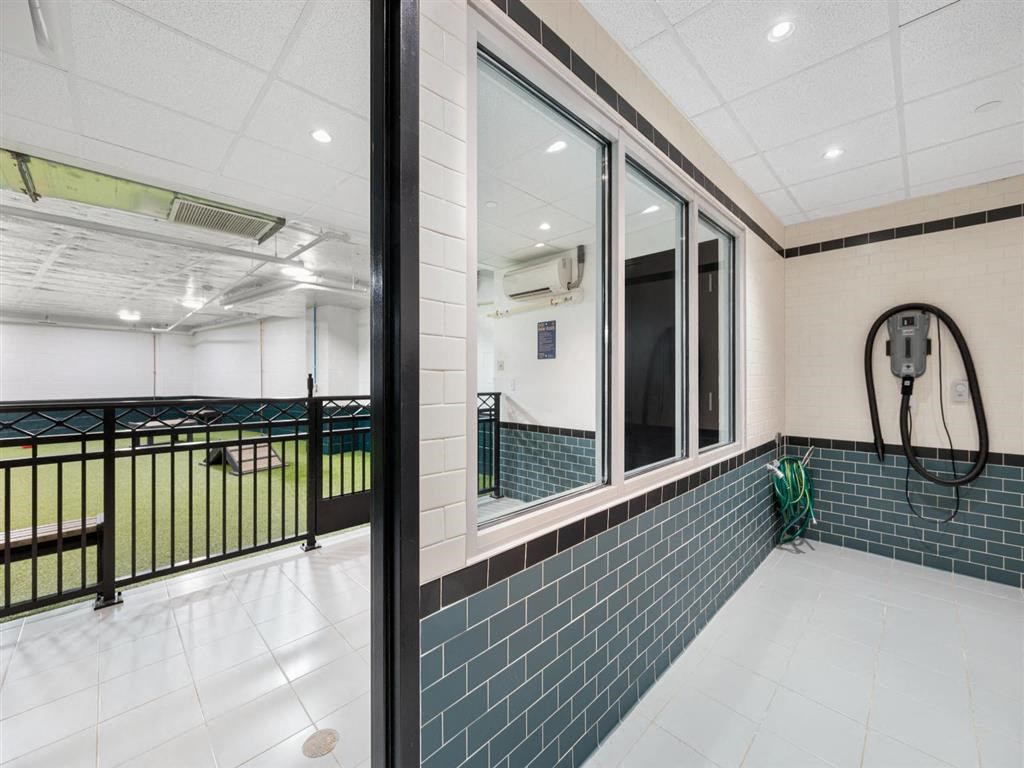 a bathroom with a mirror and a hose in the window