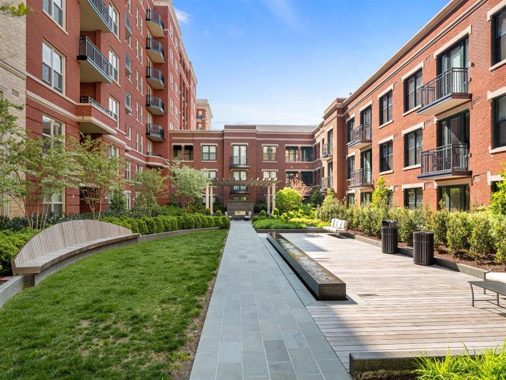 a walkway with benches in front of a building