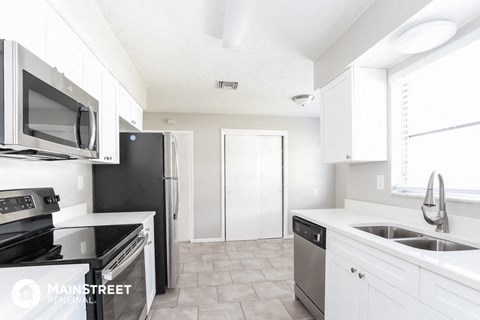 a kitchen with white cabinets and stainless steel appliances