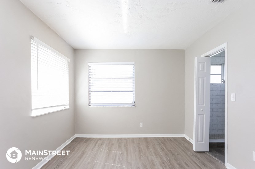 the spacious living room with a door to the bathroom