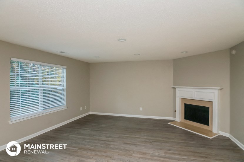 the living room of a renovated house with a fireplace