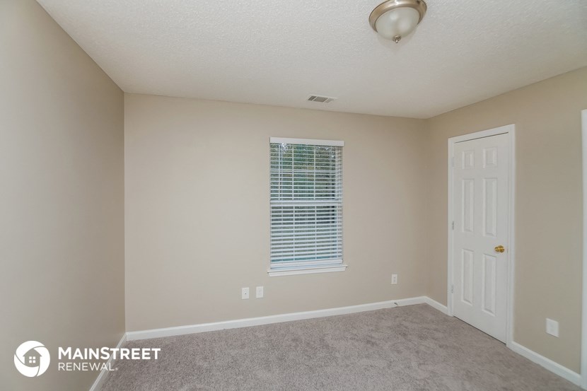 the upstairs bedroom with carpeted flooring and a white door