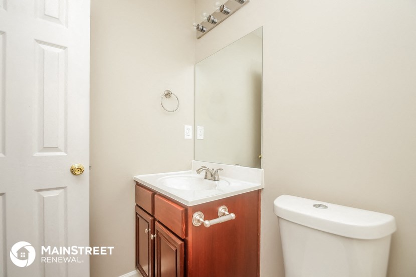 a bathroom with a toilet and a sink and a mirror