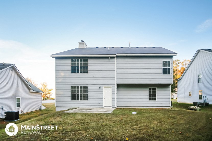 a white house with a gray roof and a grassy yard