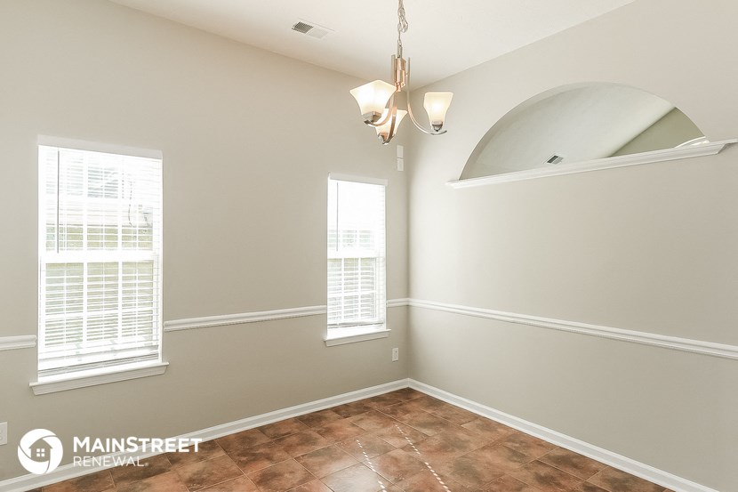 the living room of a home with a vaulted ceiling and window