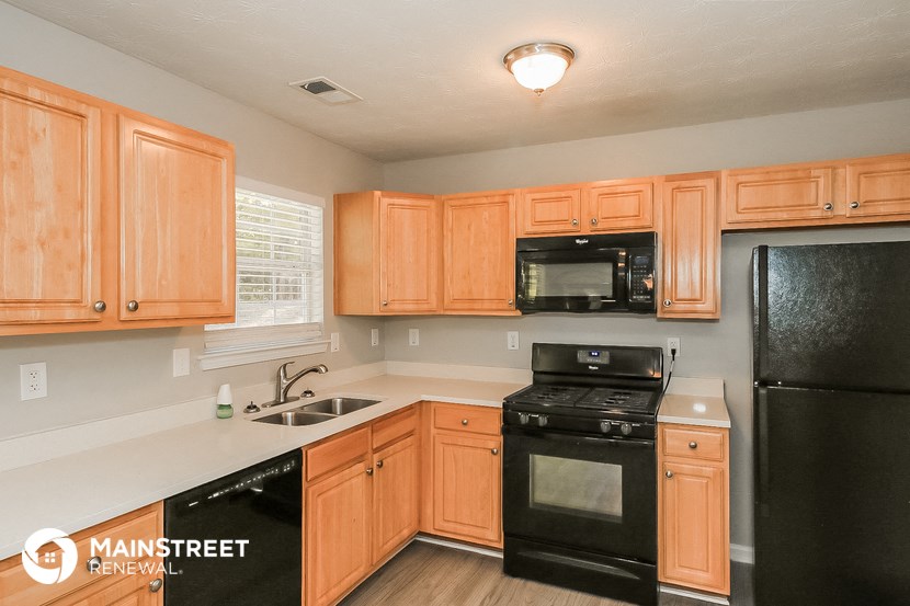 a kitchen with black appliances and wooden cabinets