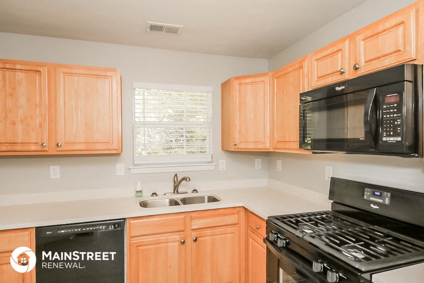 a kitchen with wood cabinets and a stove and a microwave