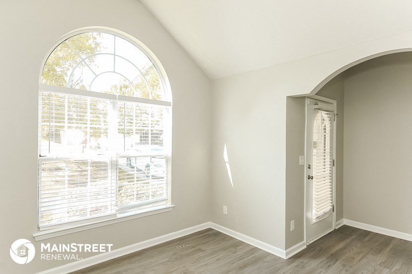 the living room of an empty apartment with a large window