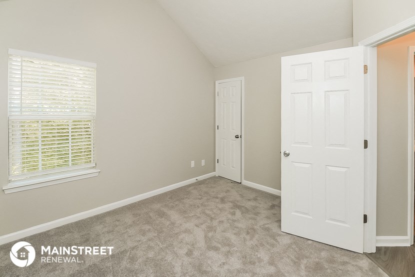 a bedroom with a closet and a door and a window