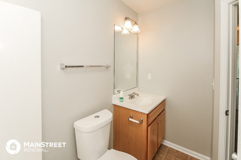 a bathroom with a toilet sink and mirror and a shower