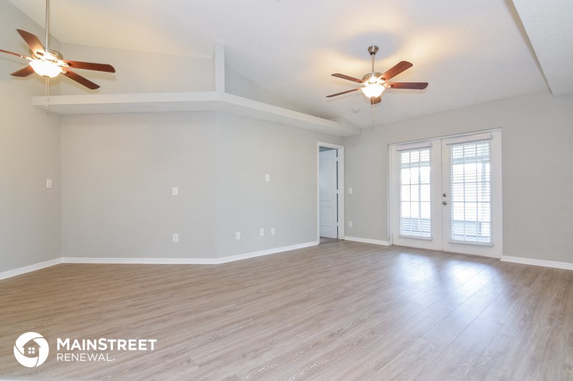 the living room of an empty house with a ceiling fan