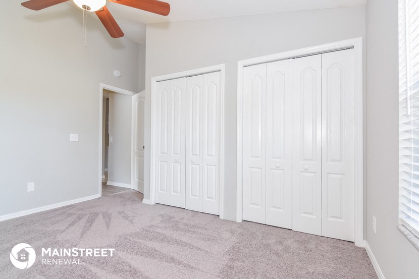 a bedroom with two closets and a ceiling fan