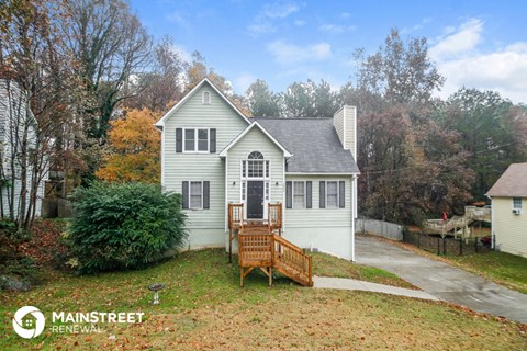a white house with a porch and a wooden bench in front