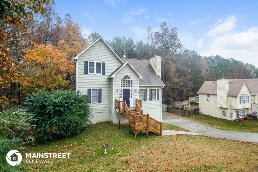 a small white house with a porch and a deck