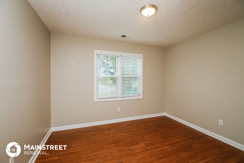the interior of an empty room with wood floors and a window